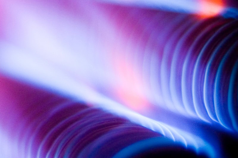 What Is That Burning Smell Coming From My Furnace? Close up photo of blue and red coils from inside a furnace.